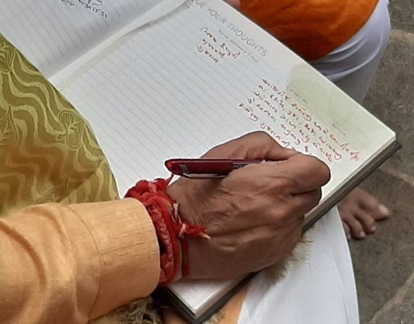 cm writing message in visitor book of mandir