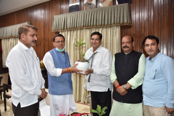 नेता प्रतिपक्ष प्रीतम सिंह  मुख्यमंत्री पुष्कर सिंह धामी को पौध भेंट करते
