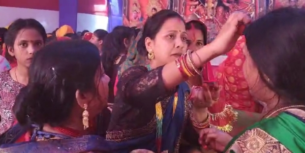 अररिया फोटो:मां दुर्गा की प्रतिमा और सुहागिन महिला एक दूसरे को सिंदूर लगाती