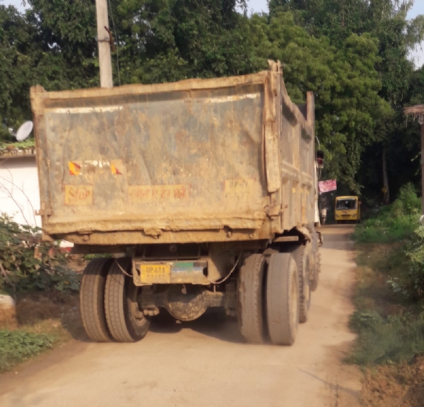 पीली मिट्टी का डम्फर ले जाते