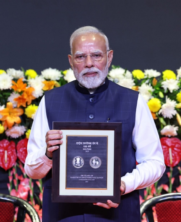 कार्यक्रम के दौरान स्मारक सिक्का जारी करते प्रधानमंत्री मोदी