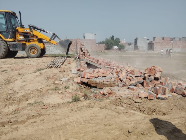 अवैध निर्माणों को जेसीबी मशीन की सहायता से ढहाते हुए।