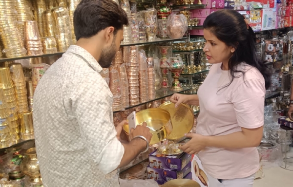 मुरादाबाद में धनतेरस पर पीतल की दुकान पर खरीदारी करती महिला।