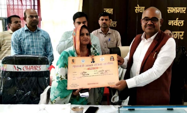 कानपुर में अल्जीरिया में हुए हादसे में दिवंगत अनादि कुमार की पत्नी सुनीता को मुख्यमंत्री आवास योजना का स्वीकृति पत्र देते जिलाधिकारी का छायाचित्र