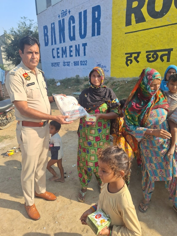 जरूरतमंदों को गिफ्ट देते हुए पुलिसकर्मी।