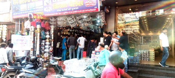 दुकान में बर्तनों की खरीददारी करते ग्राहक।