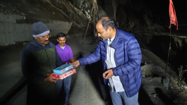 मजदूरों को मिठाई बांटते जिला अधिकारी