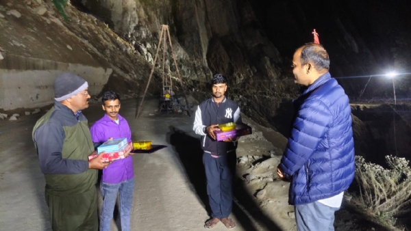 मजदूरों को मिठाई बांटते जिला अधिकारी