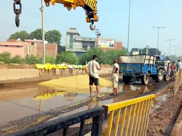 पानी में बिखरा पड़ा किसान का धान।