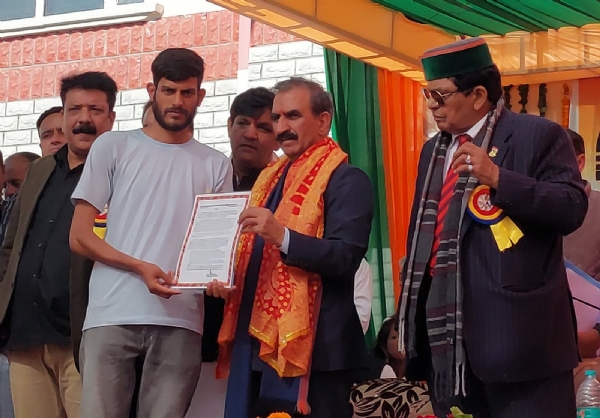 मुख्यमंत्री से जमीन के कागज लेते हुए।