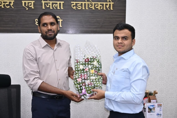 धमतरी के अनंत गुप्ता (दाएं) को पुष्पगुच्छ भेंट कर सम्मानित करते हुए कलेक्टर अबिनाश मिश्रा