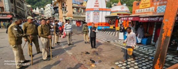 हर की पैड़ी पर अस्थाई दुकानें हटाते पुलिसकर्मी