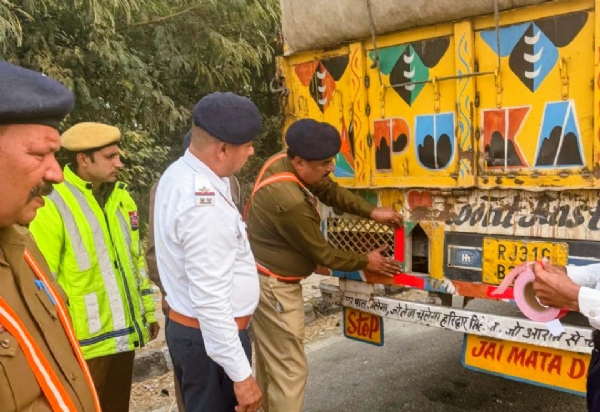पानीपत में वाहनों पर रिफ्लेक्टिव टेप लगाते यातायात पुलिसकर्मी।