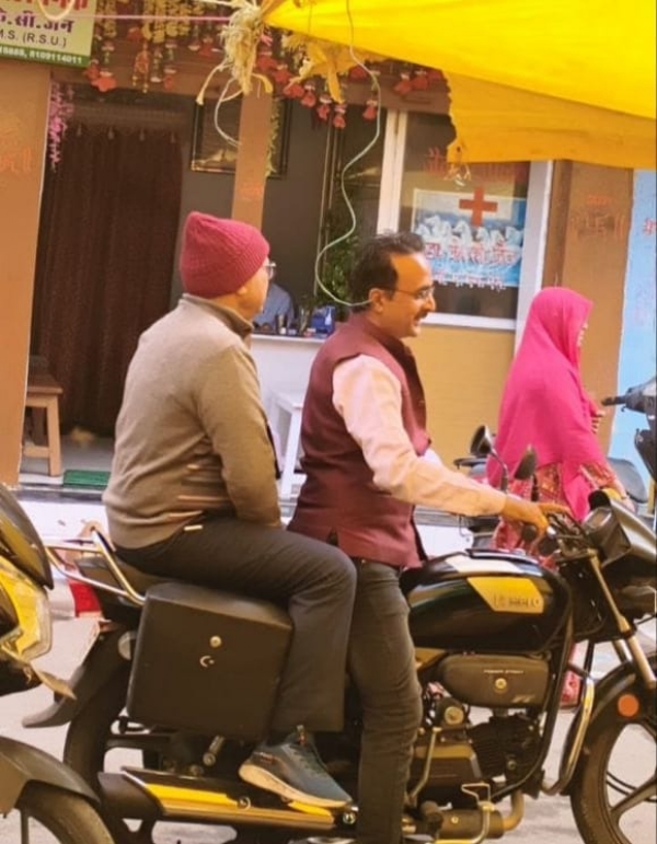 अपर कलेक्टर  बाइक से निरीक्षण के लिए जाते हुए