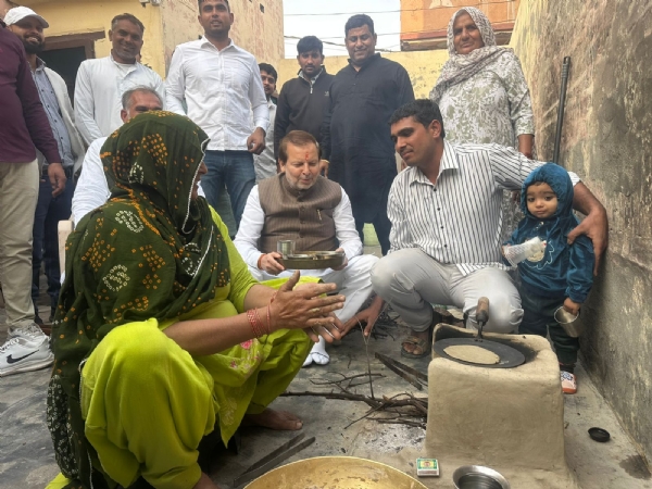 फोटो कैप्शन 26आरटीके3 : गांव टिटौली में कार्यकत्र्ता के घर देसी अंदाज में जमीन पर बैठकर खाना खाते कैबिनेट मंत्री डॉ. अरविंद शर्मा