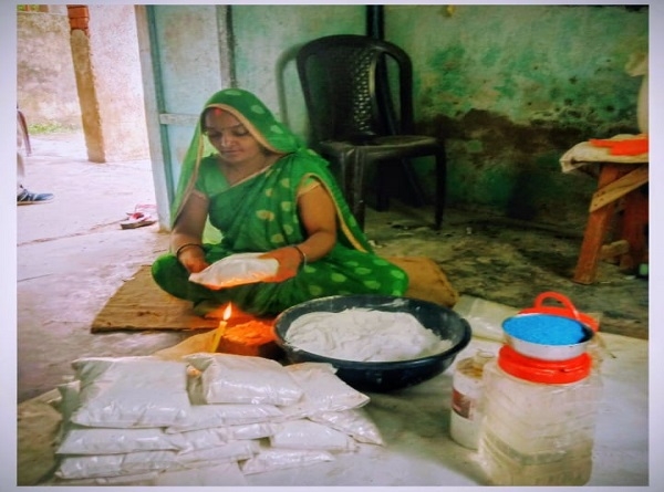 डिटरर्जेंट पाउडर पैक करती महिला डिटरर्जेंट पाउडर पैक करती महिला