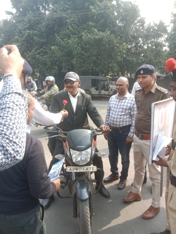 ट्रैफिक नियमों की जानकारी देने के साथ गुलाब फूल देते हुए पदाधिकारी ट्रैफिक नियमों की जानकारी देने के साथ गुलाब फूल देते हुए पदाधिकारी