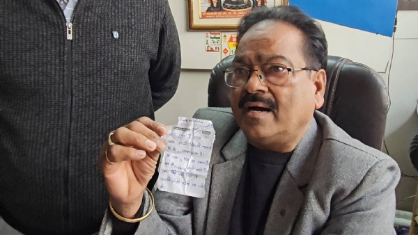 पर्ची दिखाते हुए व्यापारी।