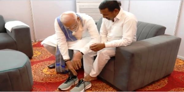 प्रधानमंत्री नरेन्द्र मोदी सोमवार को हरियाणा के यमुनानगर में कैथल के रामपाल कश्यप को जूते पहनाते हुए