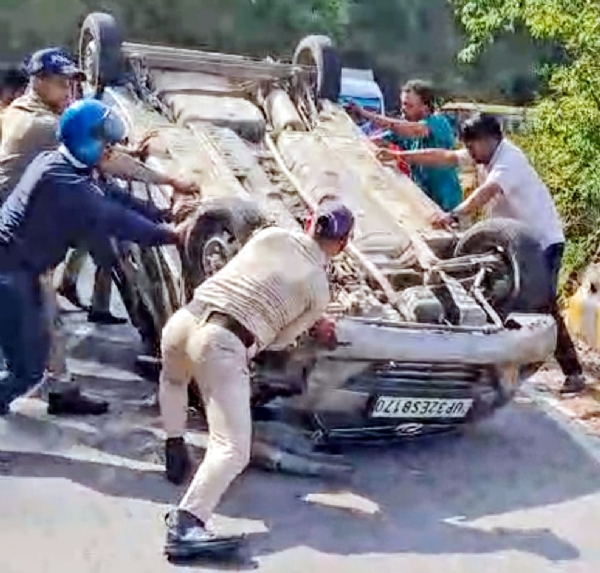 बल्दियाखान के पास कार को सीधा करने का प्रयास करते पुलिस कर्मी।