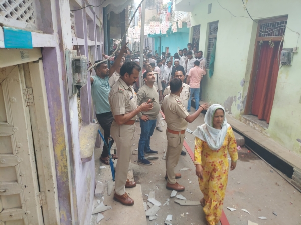 विस्फोट के बाद क्षतिग्रस्त मकान, मौके पर मौजूद पुलिस बल