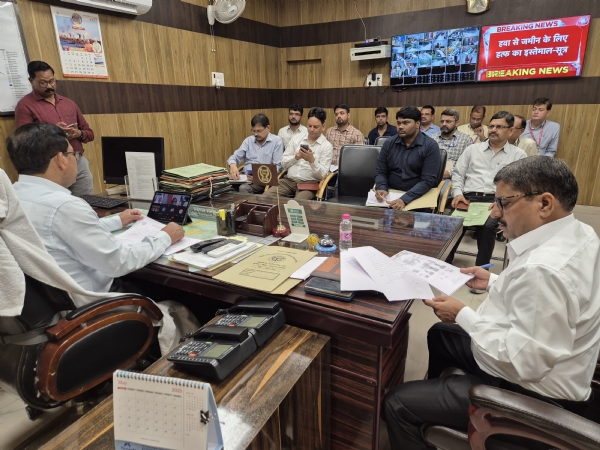 जिलाधिकारी प्रगति रिपोर्ट लेते हुए