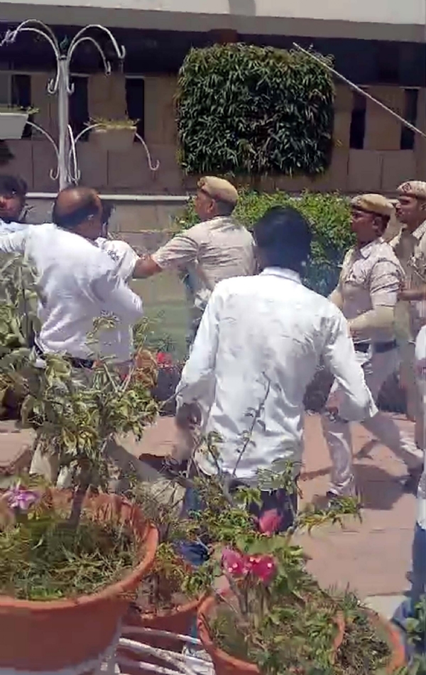 बहस के बाद छात्रों के पीछे दौड़ते सुरक्षा कर्मचारी।