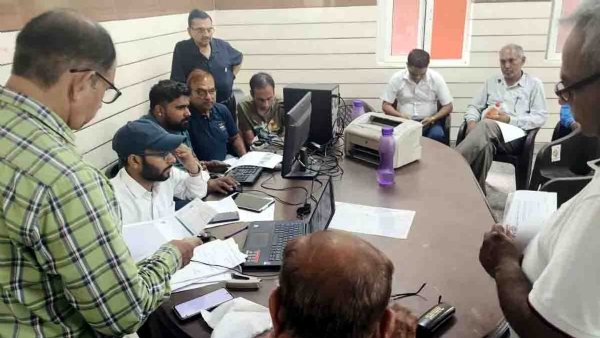 बकायेदारों की सूची बनाते निगम कर्मचारी