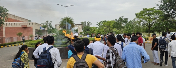 विश्वविद्यालय परिसर में पुतला फूंकते हुए छात्र।