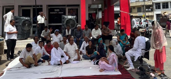 ठेके के विरोध में धरना देते दुकानदार व छात्राएं।