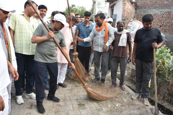 गांव उग्रा खेड़ी में सफाई अभियान के तहत झाड़ू लगाते शिक्षा मंत्री महिपाल डंडा