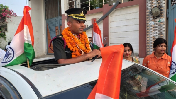 भारतीय सेना की वर्दी में गाड़ी के ऊपर खड़े होकर हाथ में तिरंगा लहराते हुए लेफ्टिनेंट तरुण सैनी। स्वागत जुलूस के दौरान जयघोषों से गूंजा वातावरण।