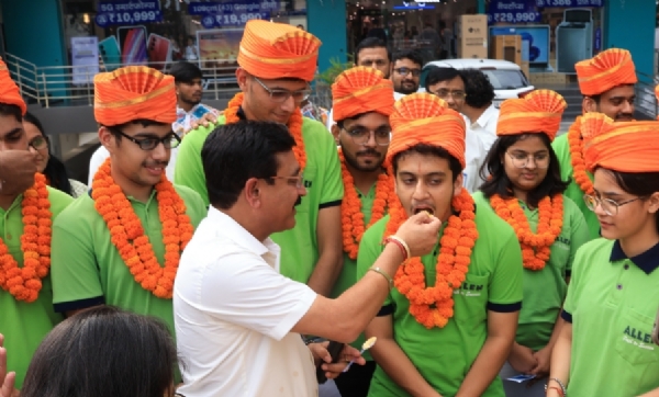 राजपुर रोड स्थित एलेन क्लास में बच्चों को मिठाई खिलाते।