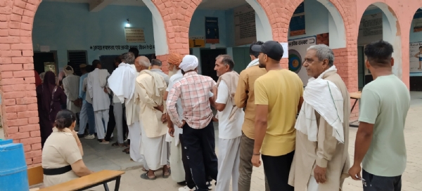 मत का प्रयोग करने के लिए लाइन में लगे मतदाता।