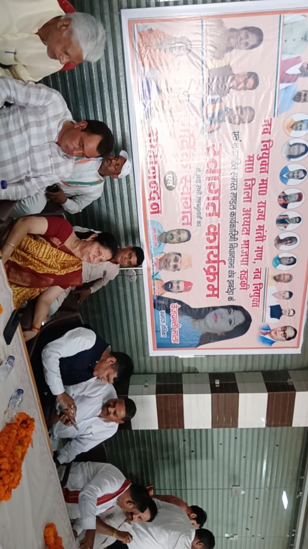 कार्यक्रम में मंचासीन भाजपा पदाधिकारीगण और अतिथि।  राज्य मंत्री सुनील सैनी, देशराज कर्णवाल, जिला अध्यक्ष डॉ. मधु सिंह समेत कई पदाधिकारियों का स्वागत संदेश प्रदर्शित।