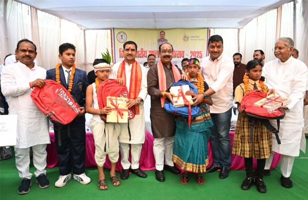 केन्द्रीय  मंत्री  तोखन साहू और उप मुख्यमंत्री  अरुण साव बच्चों को बैग और किताब वितरण करते