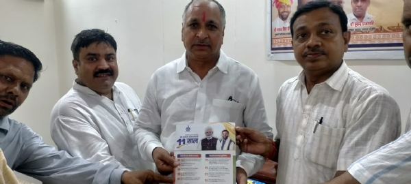 विधायक हरेंद्र रामरतन साथ में पूर्व चेयरमैन जगमोहन गोयल केंद्र सरकार के 11 साल के पोस्टर के साथ