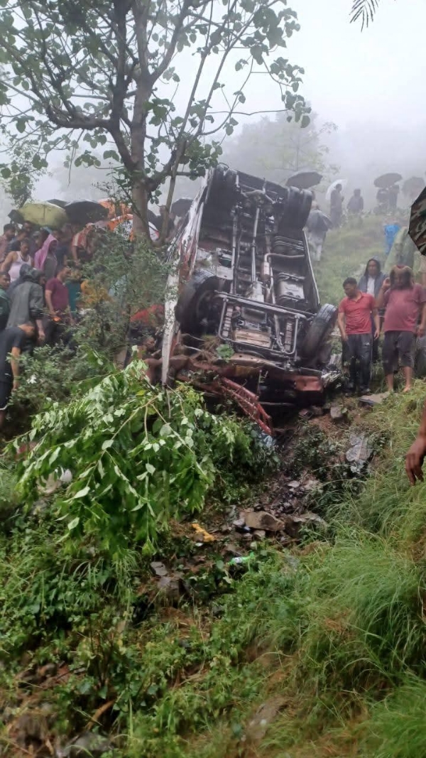 दुर्घटनाग्रस्त बस के पास राहत एवं बचाव कार्य में जुटे लोग