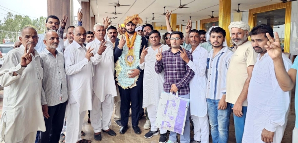 पहलवान सचिन सिंधु का गांव में पहुंचने पर फूलमाला डालकर स्वागत करते हुए ग्रामीण।