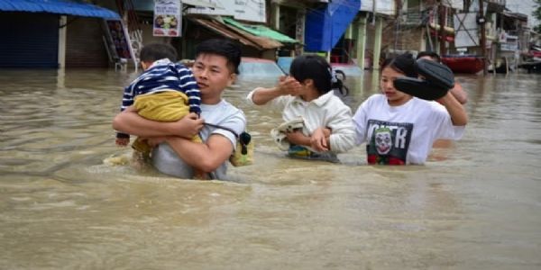 मणिपुरः सुरक्षित इलाकों की ओर जाते बाढ़ में फंसे लोग।