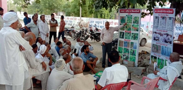 किसानों को बीजोपचार की जानकाकरी देते डॉ. बीडी यादव।
