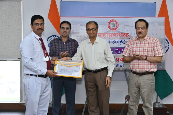 कुलदीप सिंघल, स्टेशन मास्टर को सम्मानित करते हुए रेलवे के उत्तर मध्य रेवले के महाप्रबंधक उपेन्द्र चन्द्र जोशी का छाया चित्र