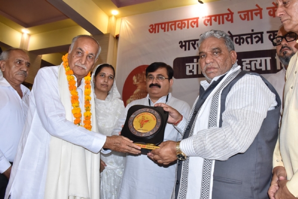 संविधान हत्या दिवस पर आपातकाल पीड़ितों को सम्मानित करते मंत्री कृष्ण लाल पंवार।