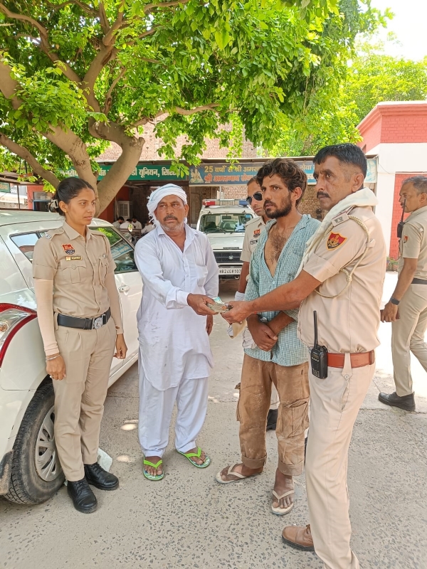 किसान को पैसे वापस लौटाते पुलिसकर्मी।