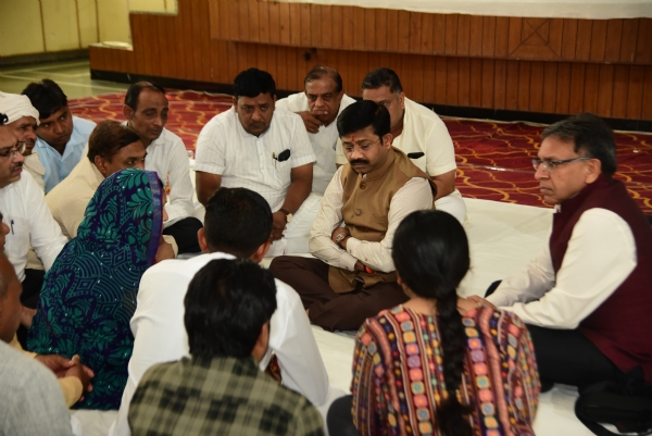 शोकाकुल परिजनों से बात करते यूपी सरकार के मंत्री नंद गोपाल नंदी