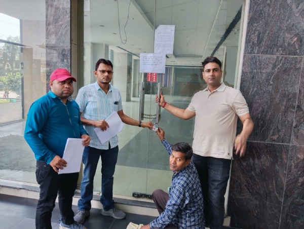 संपत्ति को सील करते निगम कर्मचारी