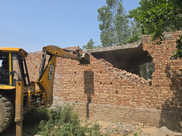 अवैध निर्माण को ध्वस्त करते हुए विभाग की जेसीबी मशीन।