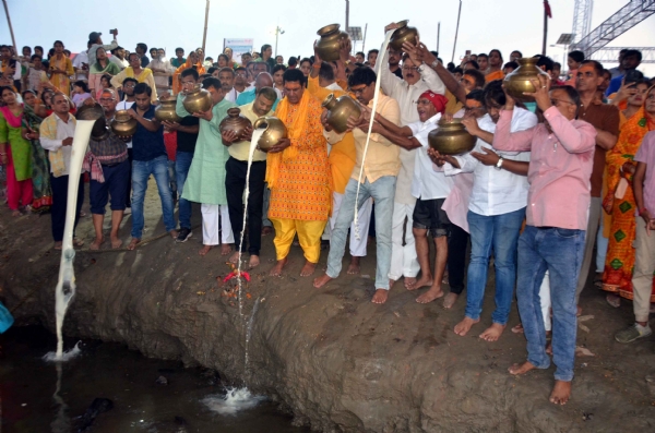 कंगन घाट पर गंगा दशहरा  के दौरान हिंदू श्रद्धालु पवित्र नदी गंगा में दूध चढ़ाते हुए।