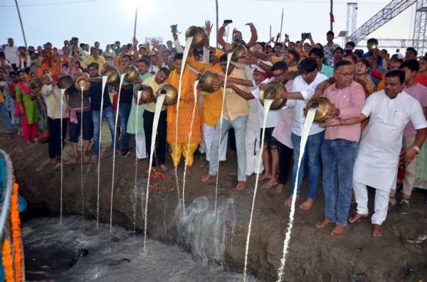 कंगन घाट पर गंगा दशहरा  के दौरान हिंदू श्रद्धालु पवित्र नदी गंगा में दूध चढ़ाते हुए।