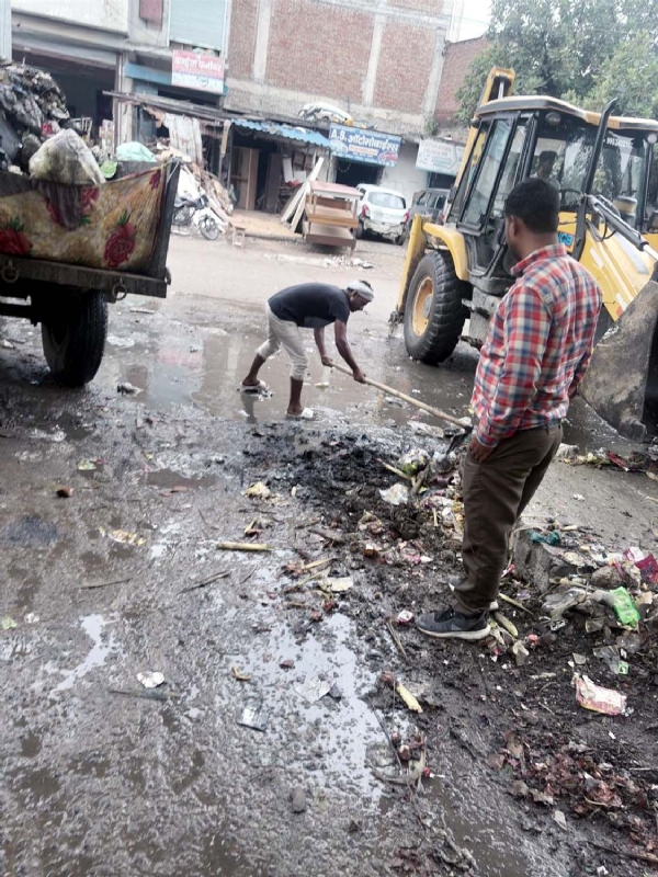 गुरुग्राम में सफाई करते नगर निगम के कर्मचारी।